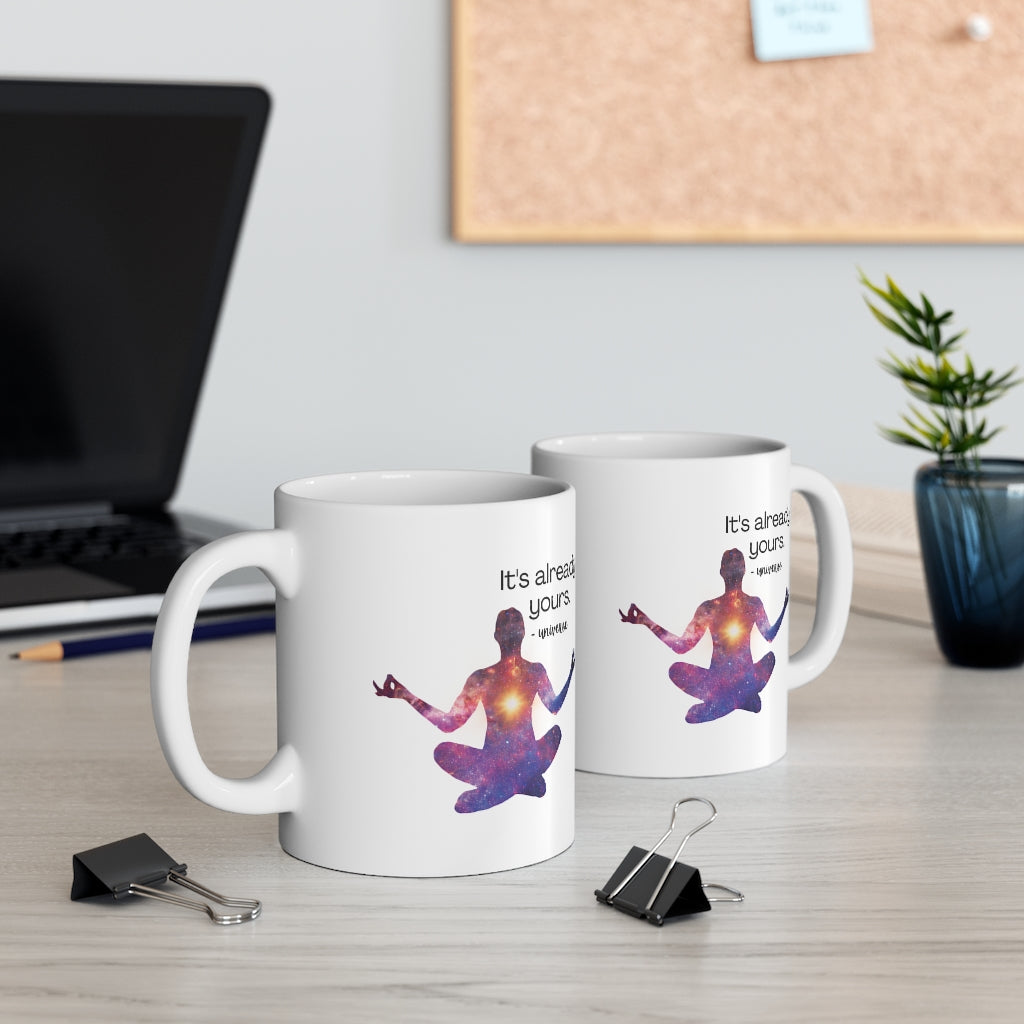 A white ceramic mug with the phrase "It's Already Yours" Message printed in elegant, motivational typography. The mug is set on desk in an office space, showcasing its inspirational message, ideal for enjoying hot beverages and uplifting one's spirits.
